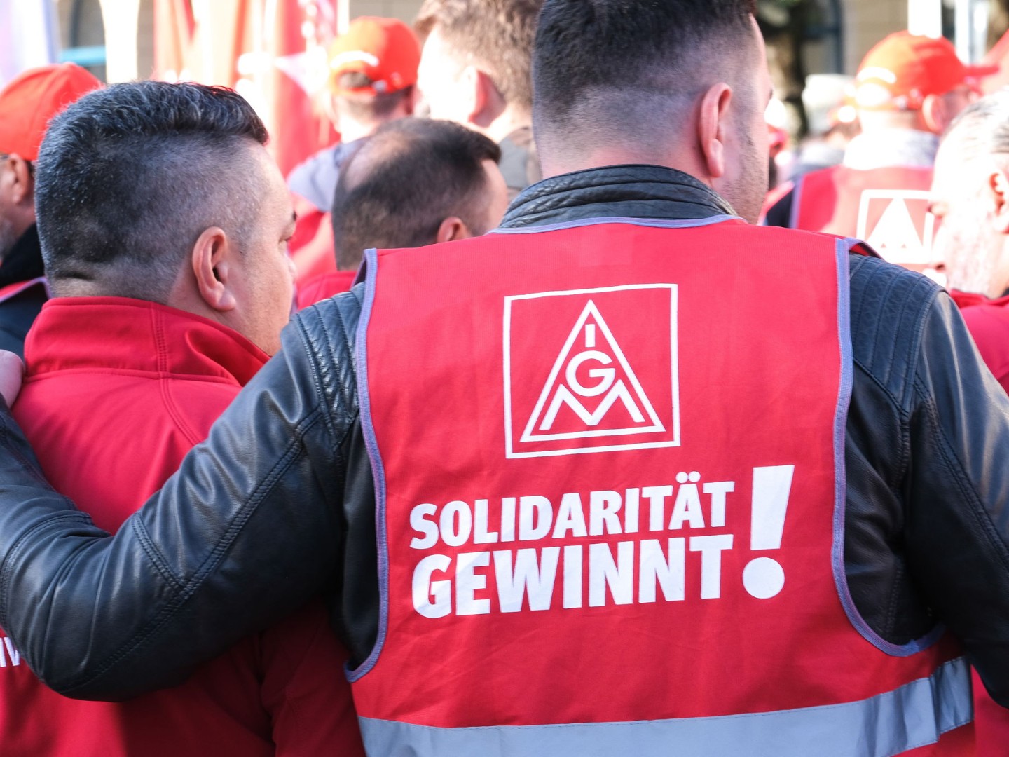 Ein Mann trägt bei einer Kundgebung eine Weste mit der Aufschrift „Solidarität gewinnt!“