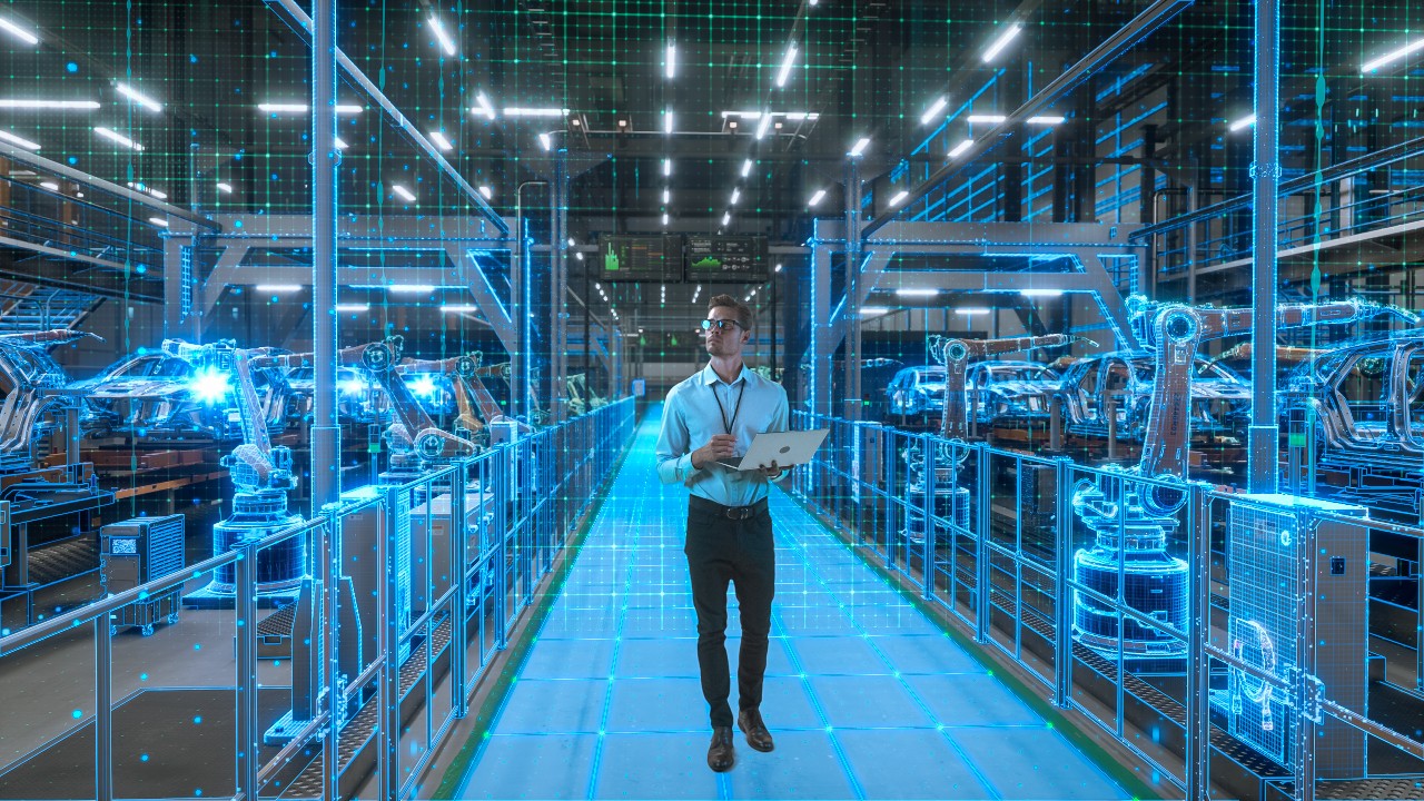 Ingenieur mit Laptop aktiviert die Digitalisierung der autonomen Fabrik. Die Visualisierung zeigt Roboterarme, Fließband, digitale Zwillinge mit Datenlinien, Computer Vision Transformation Fertigungstechnologie.